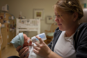 Mama feeding donated breastmilk to her premature baby